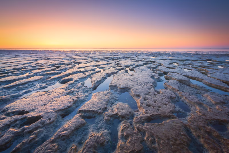 Een mooie avondgloed van de zonsondergang op de Waddenzee bij laag water