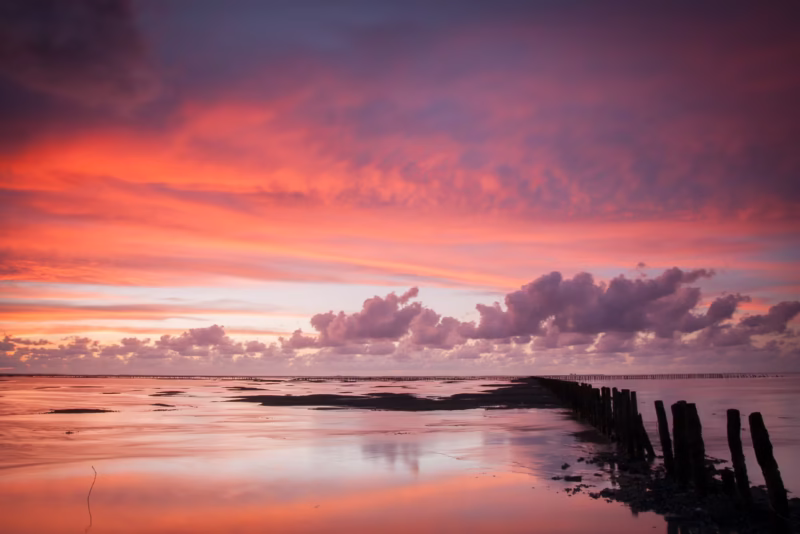 Avondrood met een mooie wolkenlucht tijdens een kalme zonsondergang op de Waddenzee