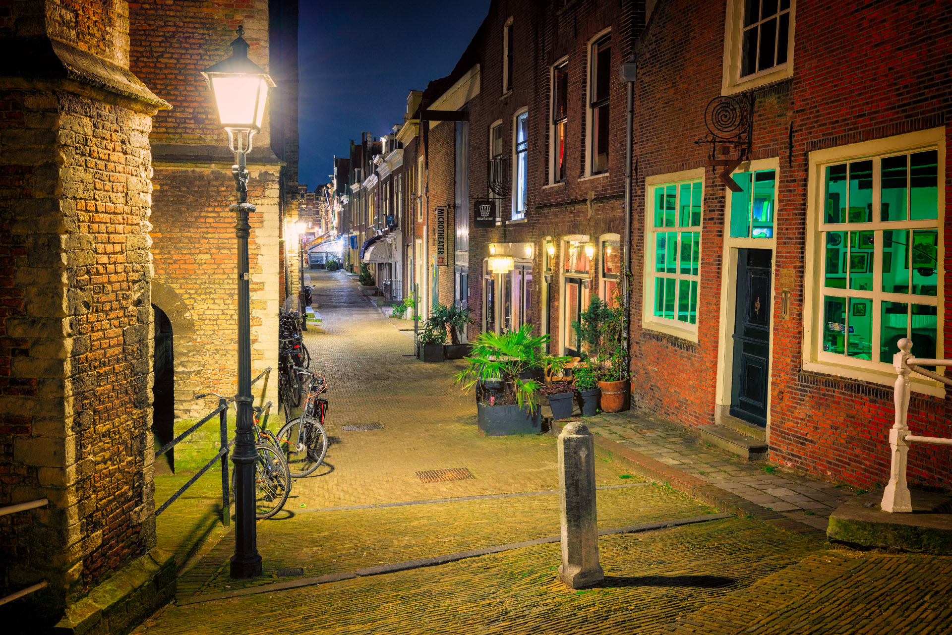 De Kerkstraat in Delft bij nacht naast de bekende Nieuwe Kerk van Delft. Een mooie oude stad met karakteristieke oude steegjes.