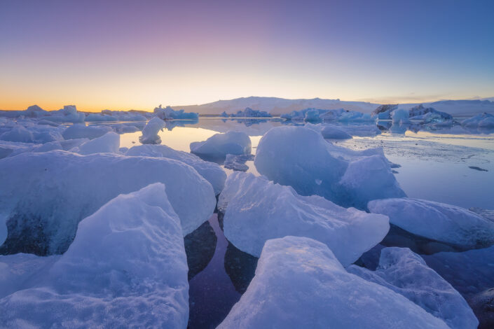 Ijsschotsen op het Jökulsarlon gletsjermeer in IJsland tijdens de zonsondergang