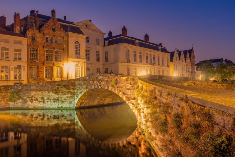 Een mooie oude brug in Brugge in de nacht met een mooie weerspiegeling