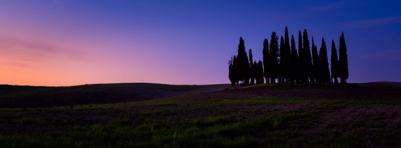 Panorama van een heuvellandschap in Toscane met cipressen tijdens de zonsopkomst
