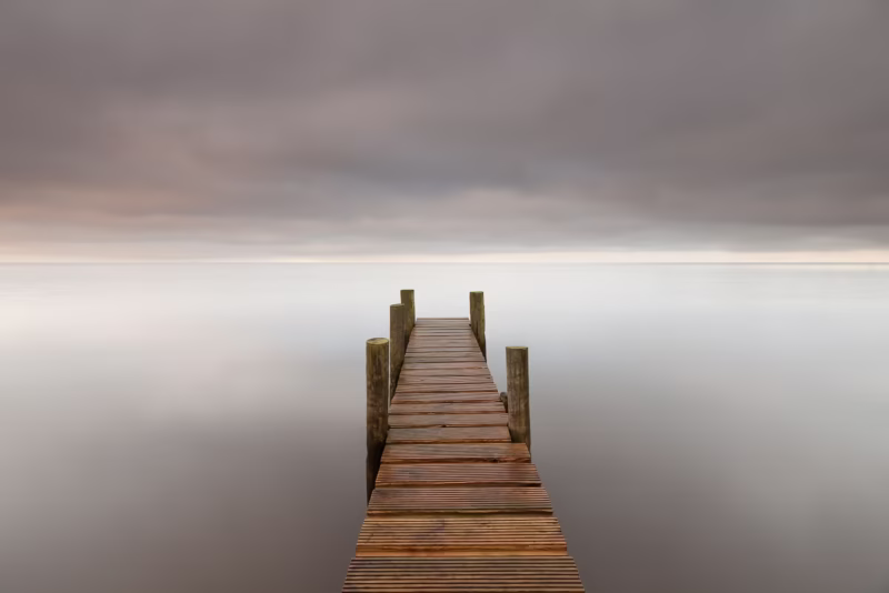 Een grijze wolkenlucht en een steiger in het water bij Giethoorn