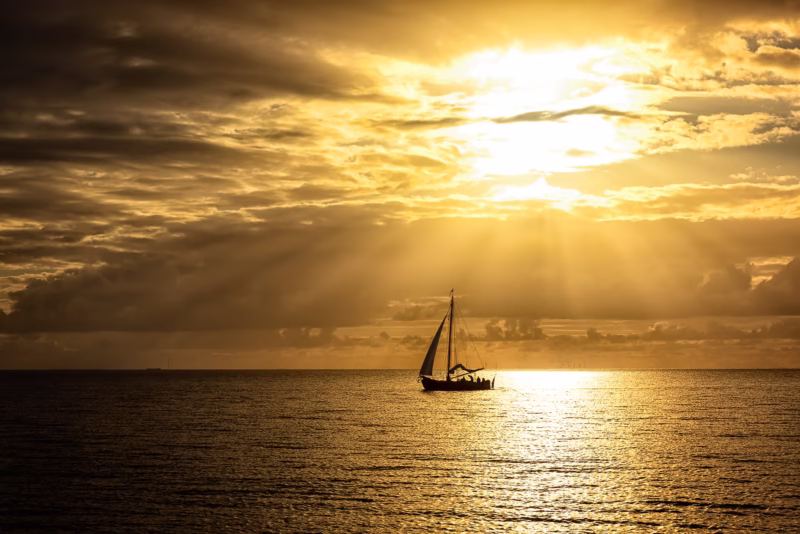 Mooie zonnestralen boven het IJsselmeer met een zeilboot