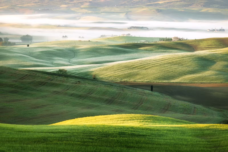 Een mooi gelaagd heuvellandschap met mist in de lente in Toscane, Italië