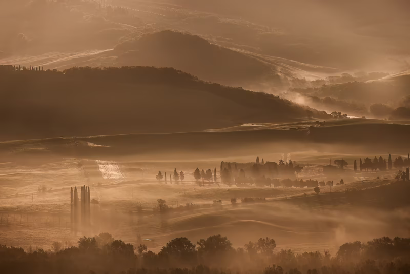 Prachtig warm ochtendlicht met mist in de heuvels van Toscane, Italië