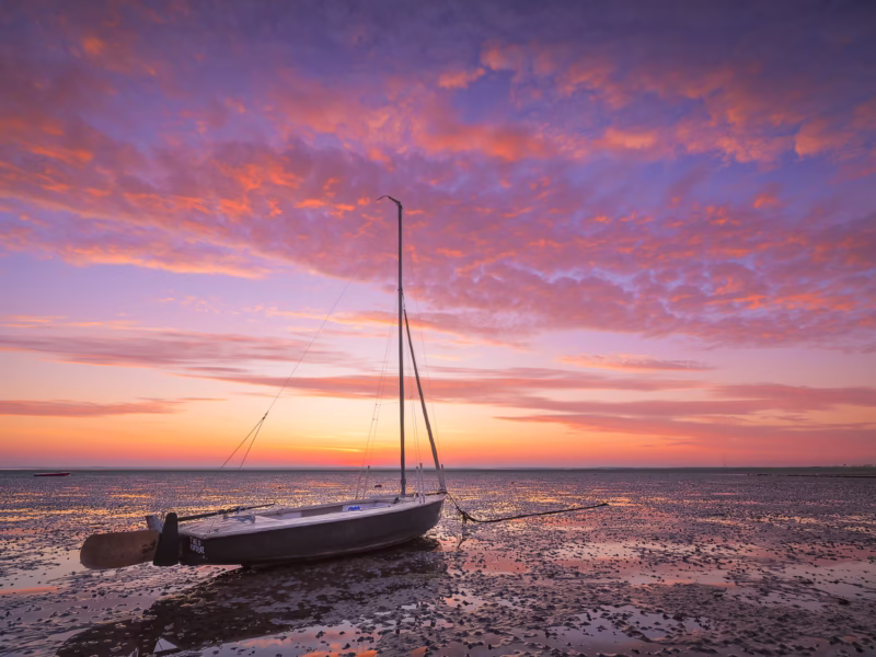 Zonsopkomst bij laag water bij de Oosterschelde in Zeeland met ochtendrood