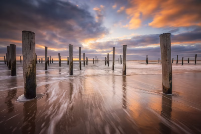 Het palendorp op het strand van Petten tijdens de zonsondergang