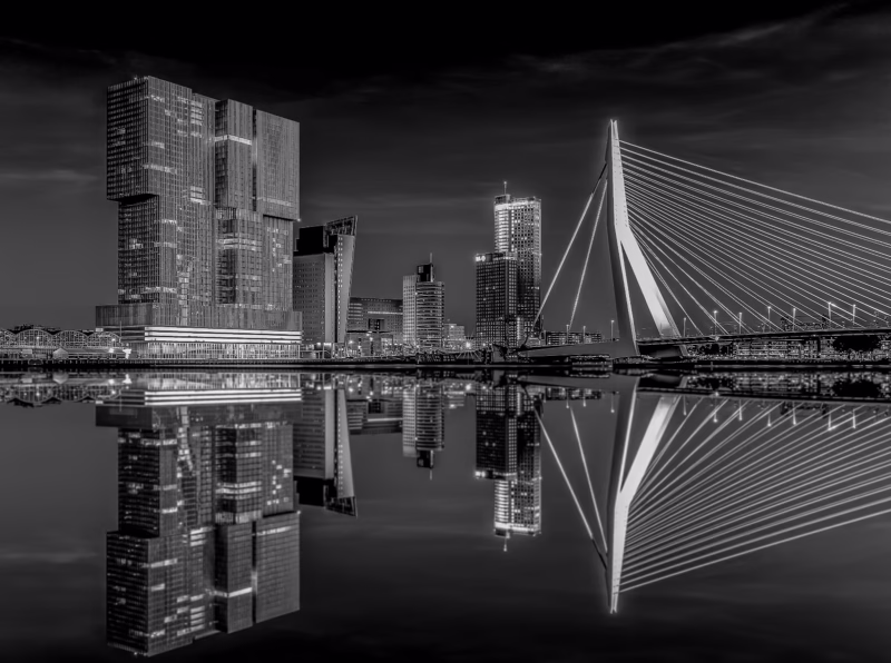 De Erasmusbrug in Rotterdam in de nacht met een mooie weerspiegeling in de Nieuwe Maas