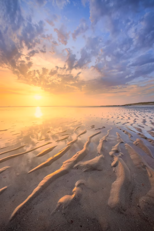 Een mooie wolkenlucht tijdens de zonsondergang op het strand van Burgh-Haamstede