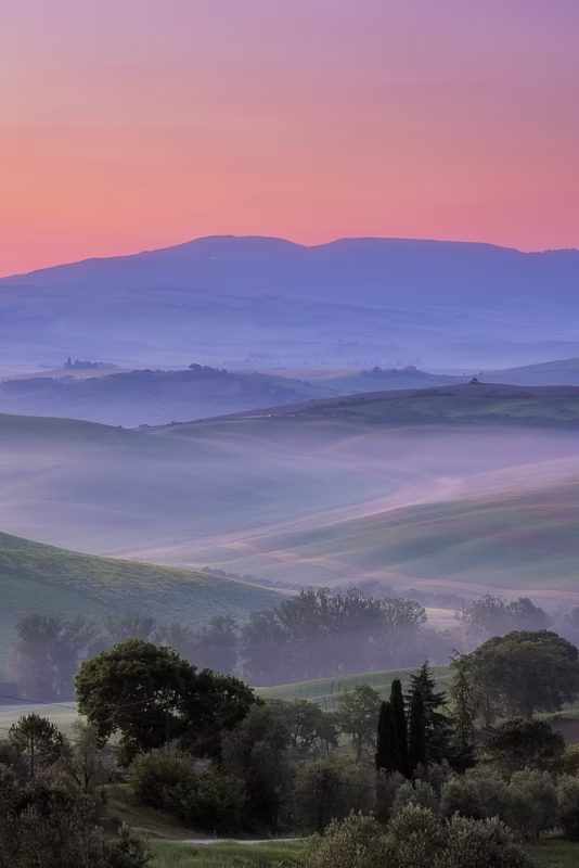 Zonsopkomst boven ene mooi gelaagd landschap in Toscane, Italië,