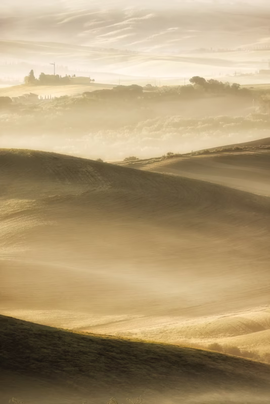 Een mooi gelaagd Toscaans landschap met mist tussen de heuvels