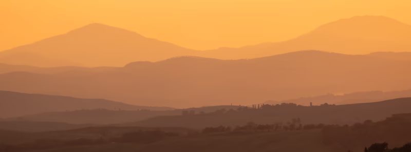 Een panorama van een heuvellandschap in Toscane, Italië tijdens de zonsondergang met gouden licht