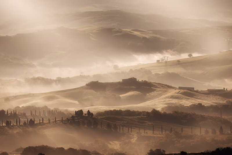 Een mistige zonsopkomst in de heuvels van Toscane in Italië