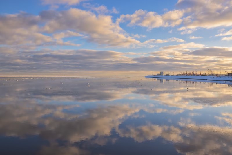 Een mooie wolkenlucht weerspiegeld in de Waddenzee bij de haven van Lauwersoog in de winter