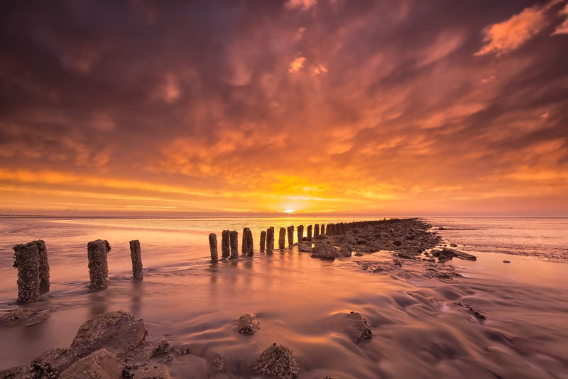 Wonderlijke Waddenzee - Een prachtige zonsondergang op de Waddenzee met avondrood en terugtrekkend tij