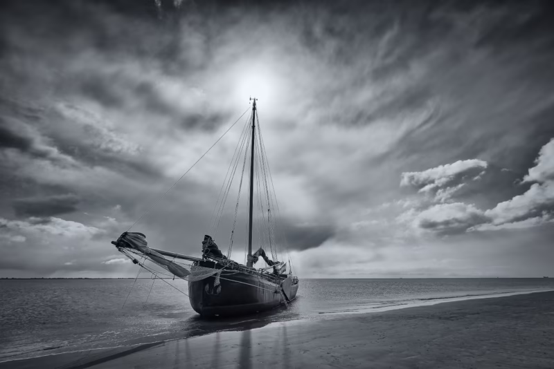 Een zeilboot is drooggevallen op de Waddenzee