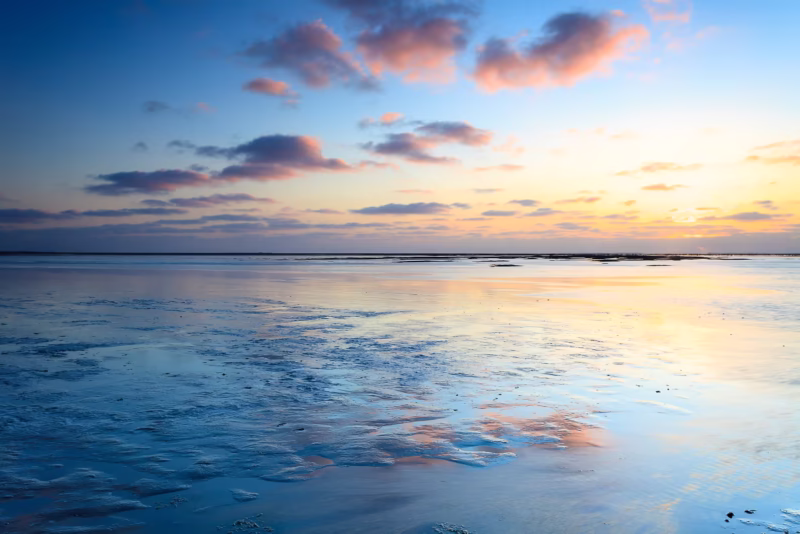 Een kalme zonsondergang met mooie reflecties op de Waddenzee