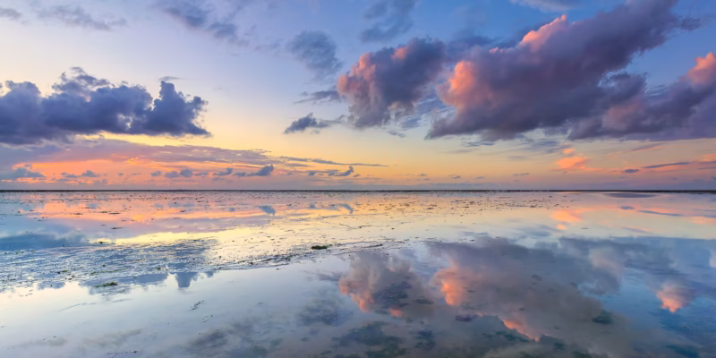 Een mooie reflectie van de wolkenlucht op de Waddenzee tijdens zonsondergang