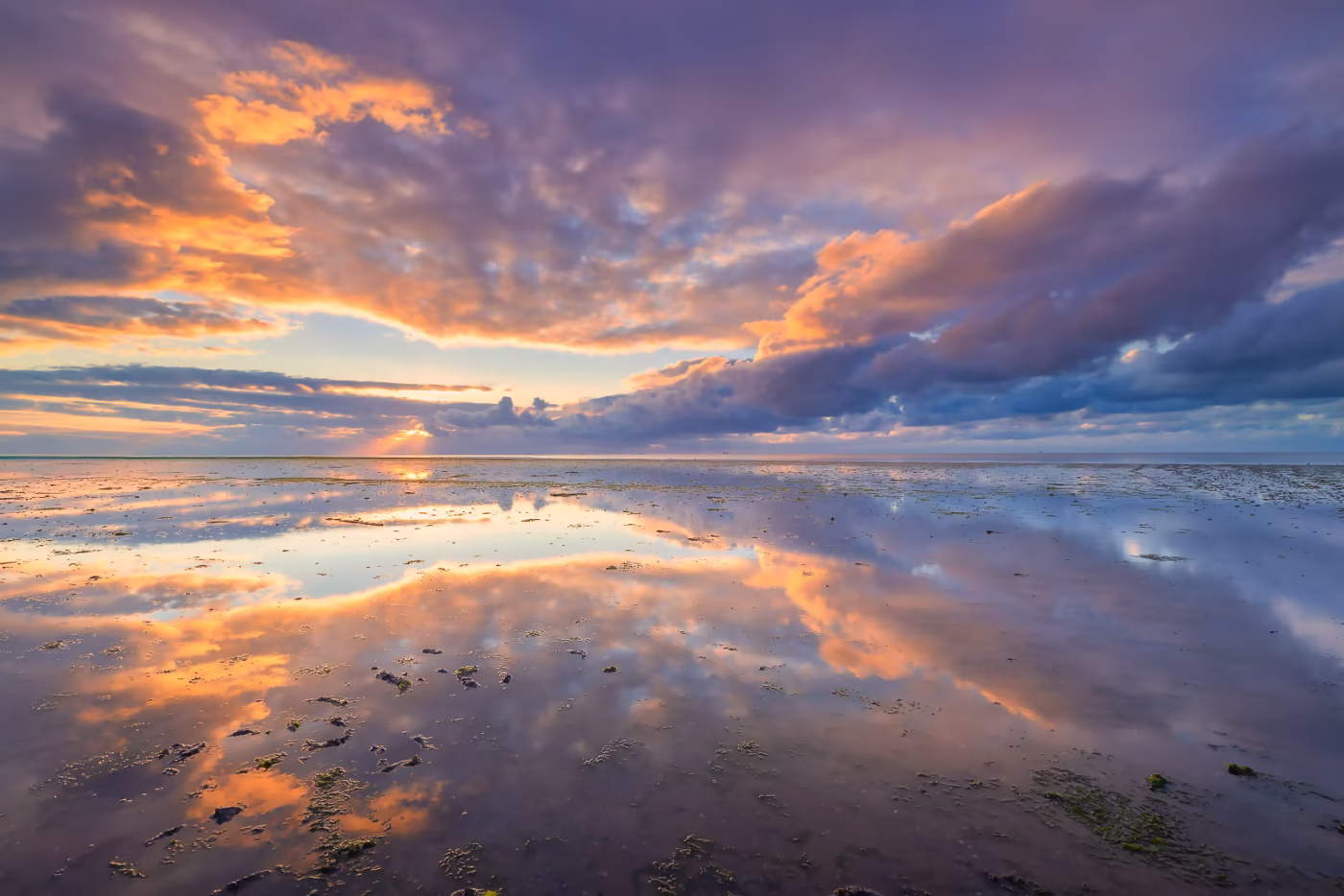 De Waddenzee met een mooie weerspiegeling van de wolkenlucht De Waddenzee met een mooie weerspiegeling van de wolkenlucht