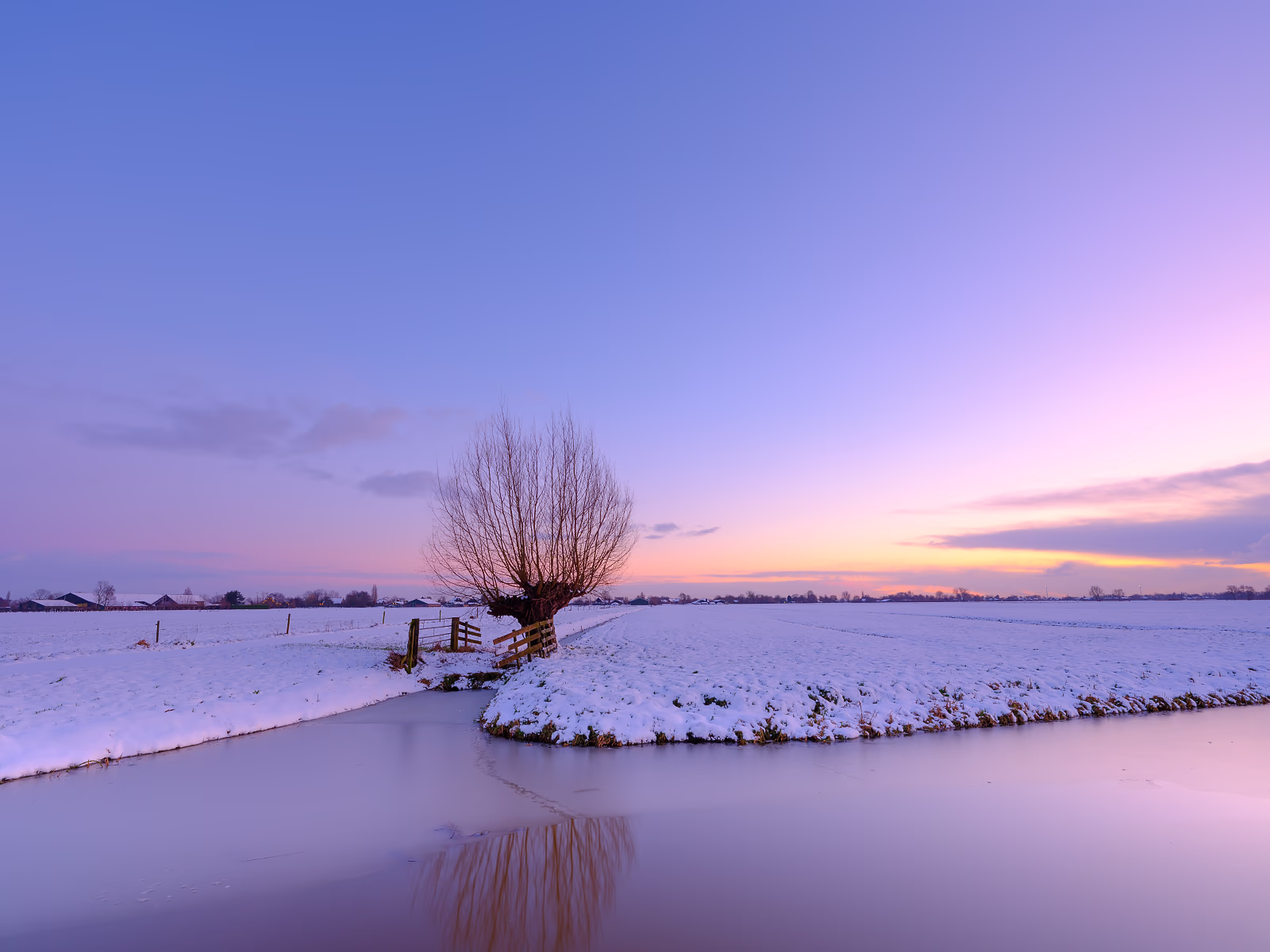 Een koude zonsondergang in de Winter met sneeuw over de weilanden - Noordeloos, Nederland