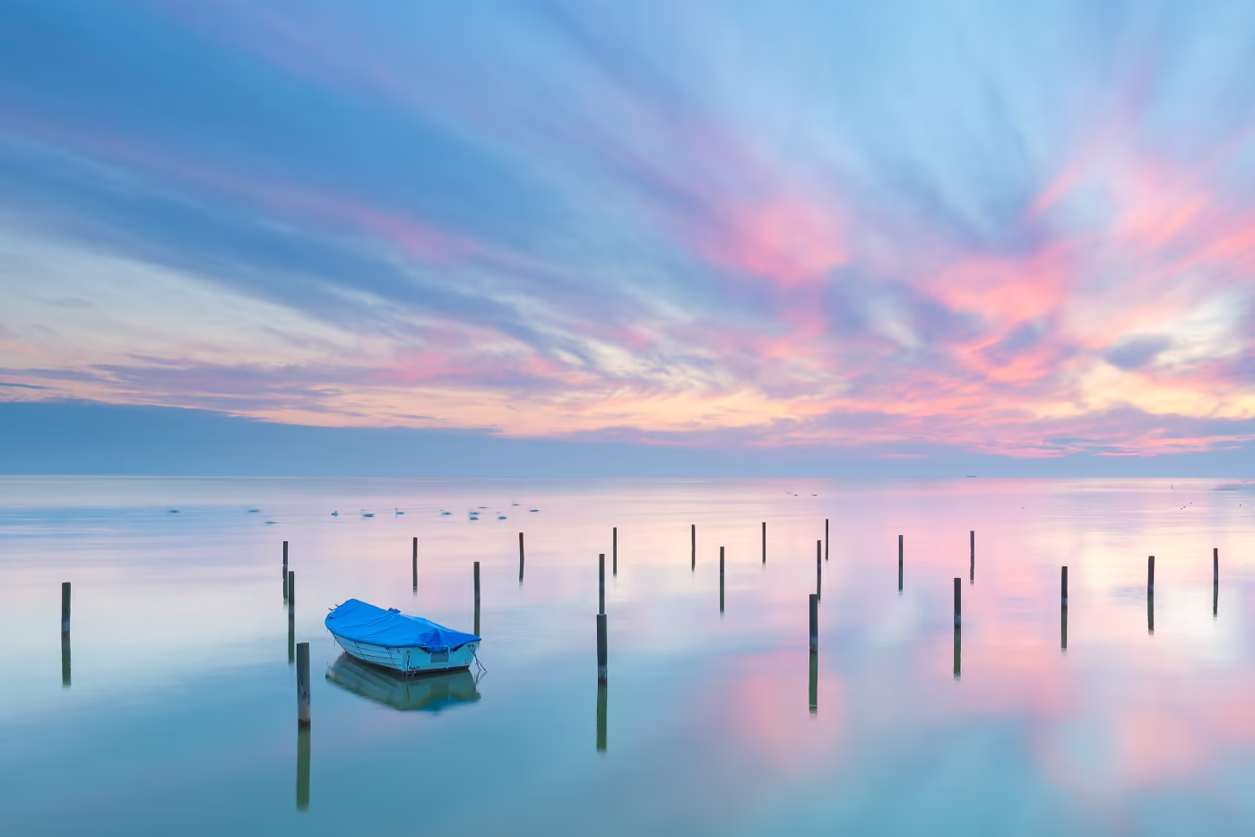 Het IJsselmeer bij Hindeloopen tijdens een kalme zonsondergang met een bootje in het water