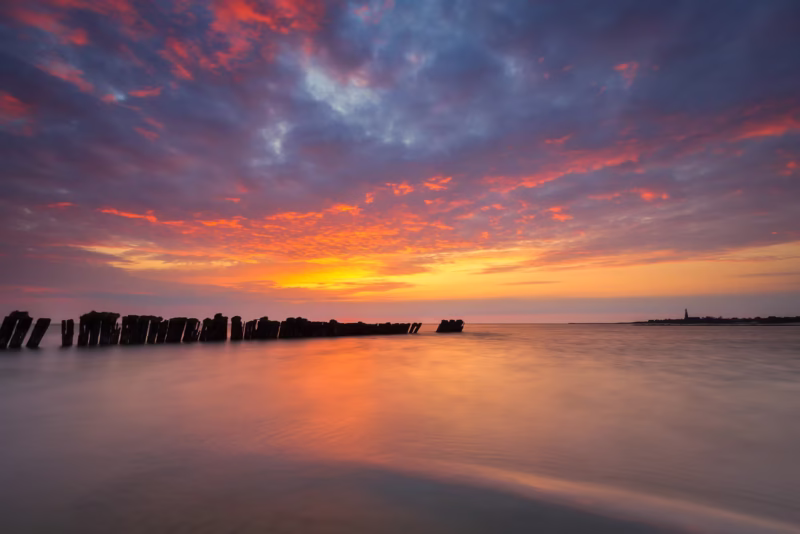 De palen bij Hindeloopen in het IJsselmeer tijdens een spectaculaire zonsondergang