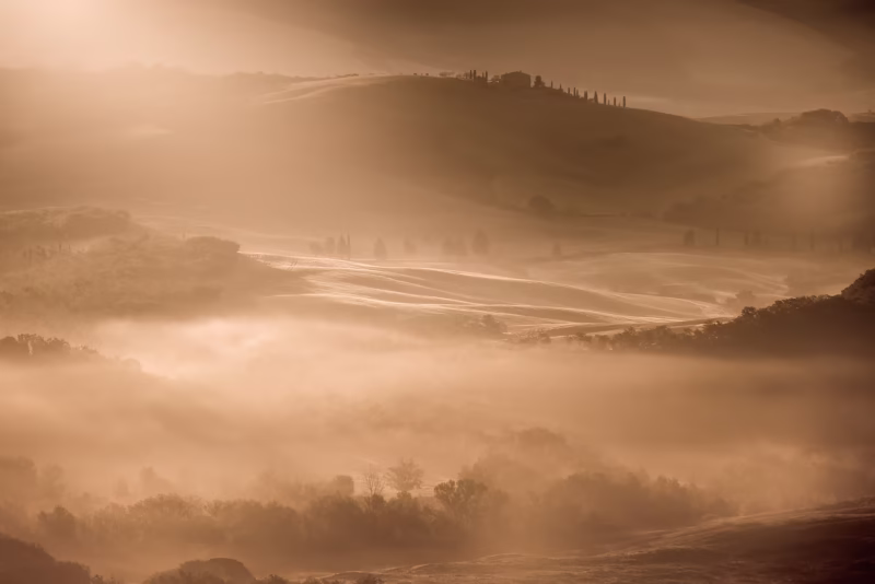 Zonsopkomst over het heuvellandschap in Toscane met mist in de valleien